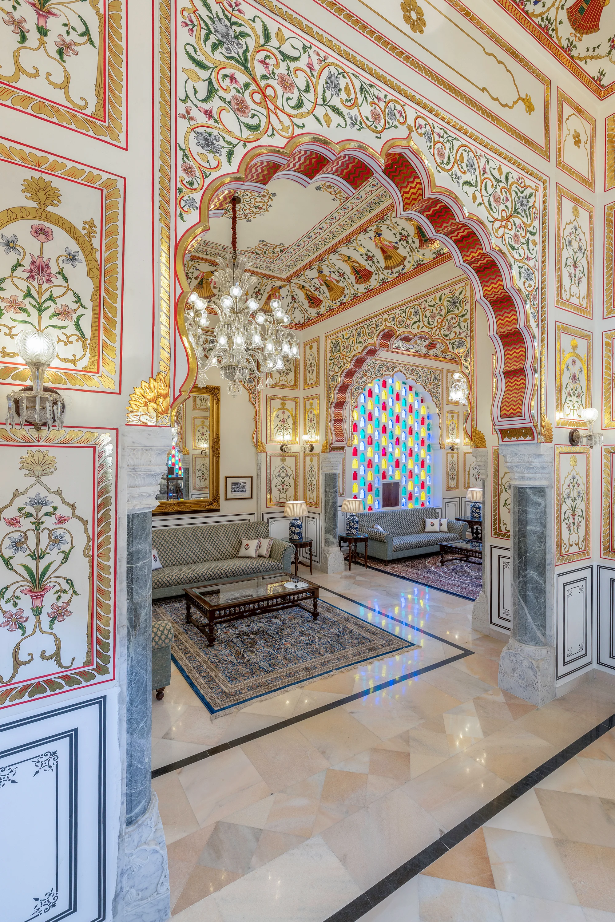 Abheygarh's sitting room with painted floral arches, chandeliers and colourful stained-glass windows